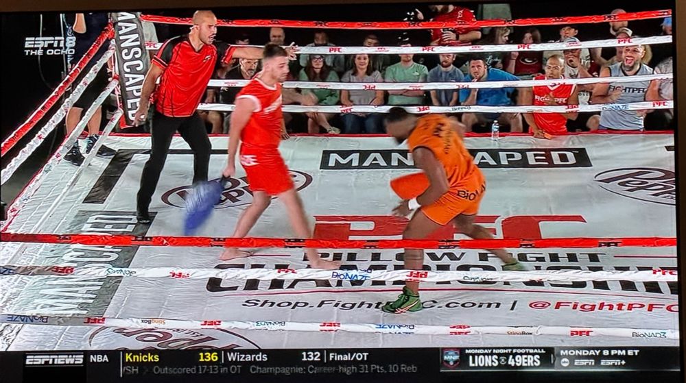 Professional pillow fighters in red and orange outfits fight for the championship on ESPN8. 