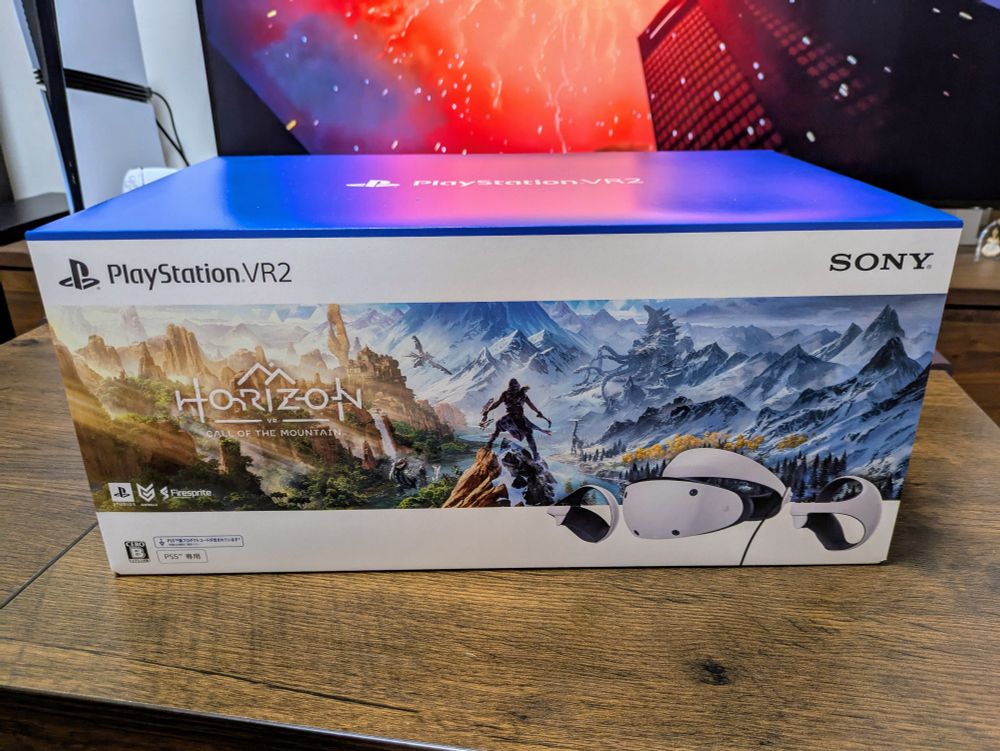 플레이스테이션 VR2(게임 '호라이즌 콜 오브 더 마운틴' 동봉판) 박스 사진입니다. 가로로 긴 박스의 왼쪽 위에는 PlayStation VR2 로고, 오른쪽 위에는 SONY 로고가 있고, 가운데에는 게임 로고와 험준한 산맥이 보이는 키 비주얼, 오른쪽 아래에는 PSVR2 헤드셋 사진이 보입니다.