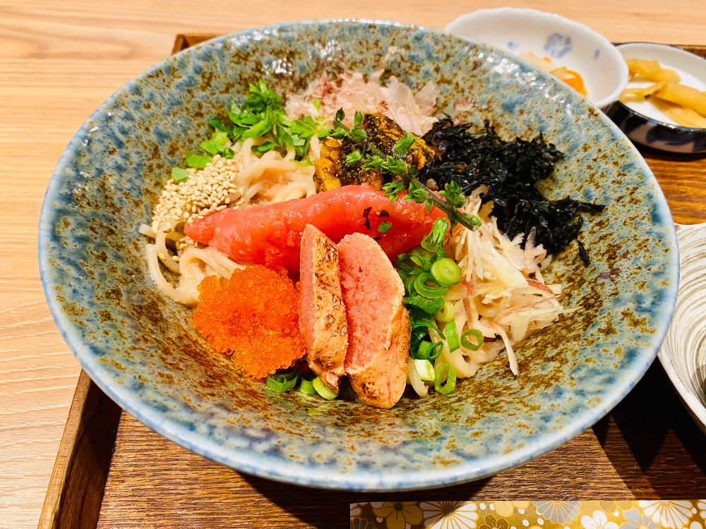 ‘도쿄 타라코(명란젓) 스파게티’ 하라주쿠/오모테산도점의 4종 명란젓 다시(일본식 육수) 스프 스파게티 정식 중 스파게티 클로즈업. 4종류의 조리 방식이 다른 명란젓(알집 하나 그대로/잘라서 겉을 살짝 구운 것/다시마와 함께 삶은 것/알알이 톡톡 터지는 것)과 김가루, 파채 등이 올라가 있고, 파스타면이 그 아래 살짝 보입니다.