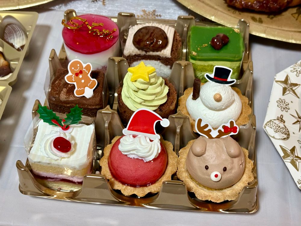 크리스마스 파티의 컵케이크. 3X3단 틀 안에 크리스마스 트리, 눈사람, 산타, 순록 등의 모양을 한 컵케이크가 총 9개 들어 있습니다.