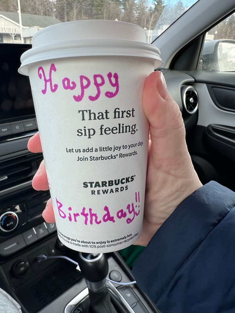 To go cup of Starbucks coffee with Hapoy Birthday written on cup 