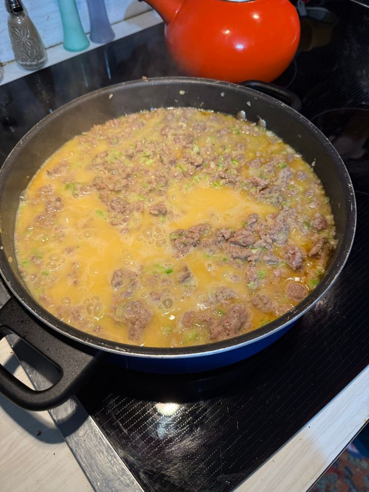 A pot of sausage and butter cooking. 