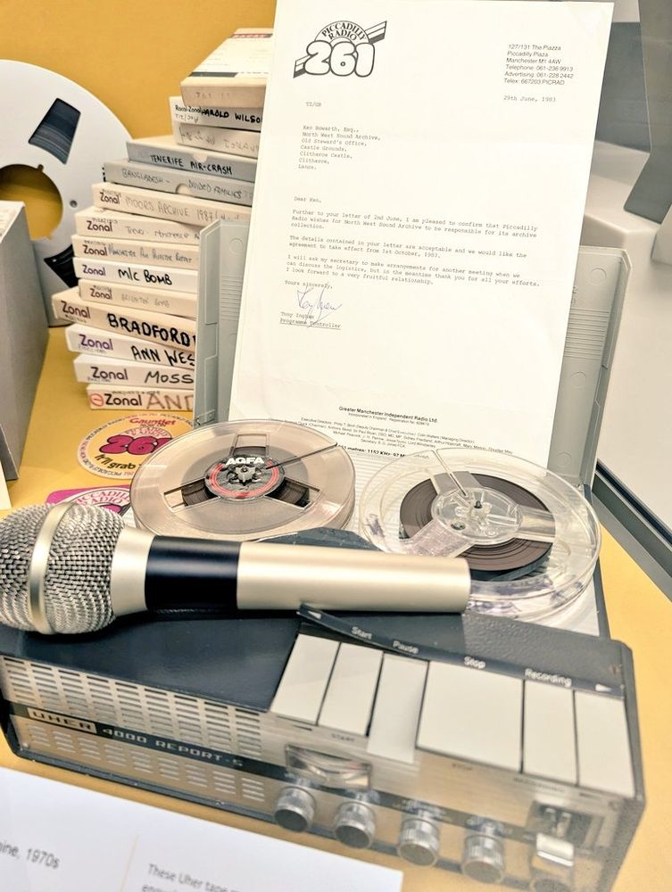 Exhibition featuring vintage UHER tape recorder, tapes and boxes
