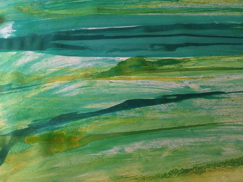 Green and yellow inks smeared in thick overlapping streaks on a white sheet of paper.