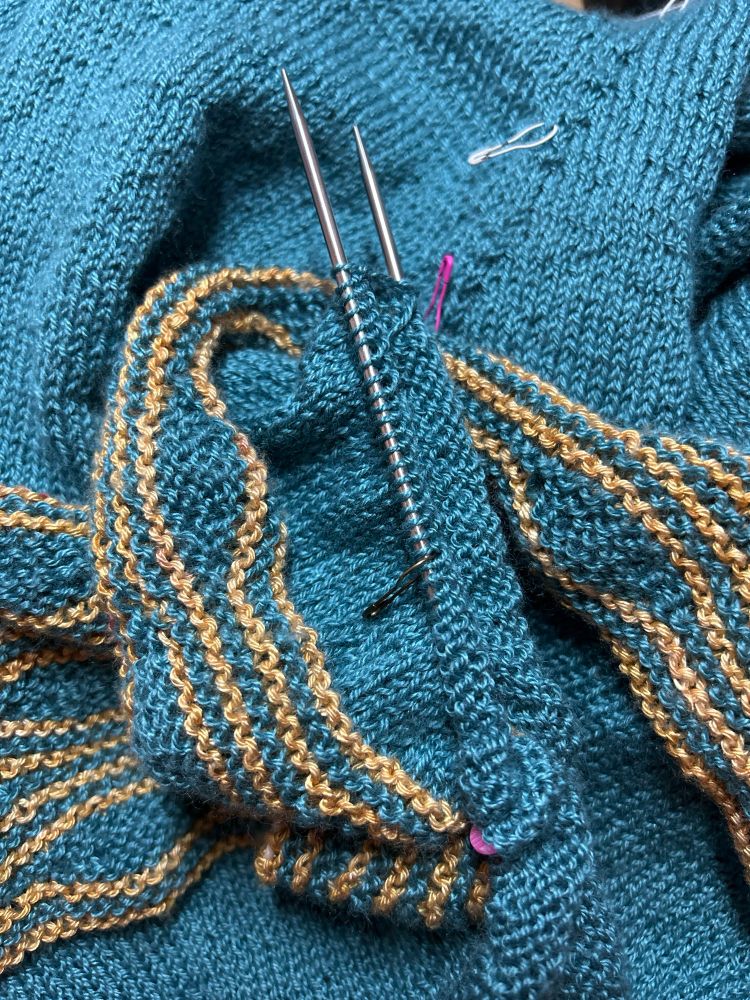 Pile of knitting in turquoise and gold, someday it will be a light- weight tunic sweater