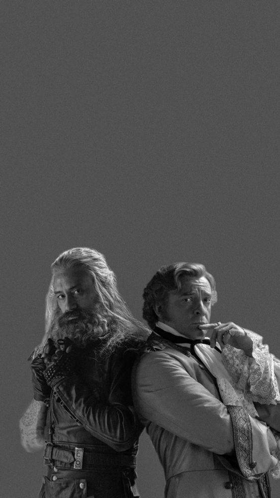 new promo photo from ofmd s1 of edward teach and stede bonnet standing back to back but in the dimensions of a phone wallpaper but it's edited to black and white