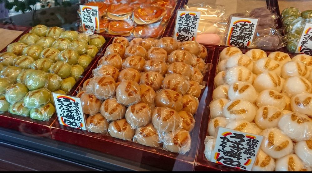 Étale de mochis (gâteaux de riz gluants japonais) avec des dizaines de mochis de toutes les couleurs empilés 