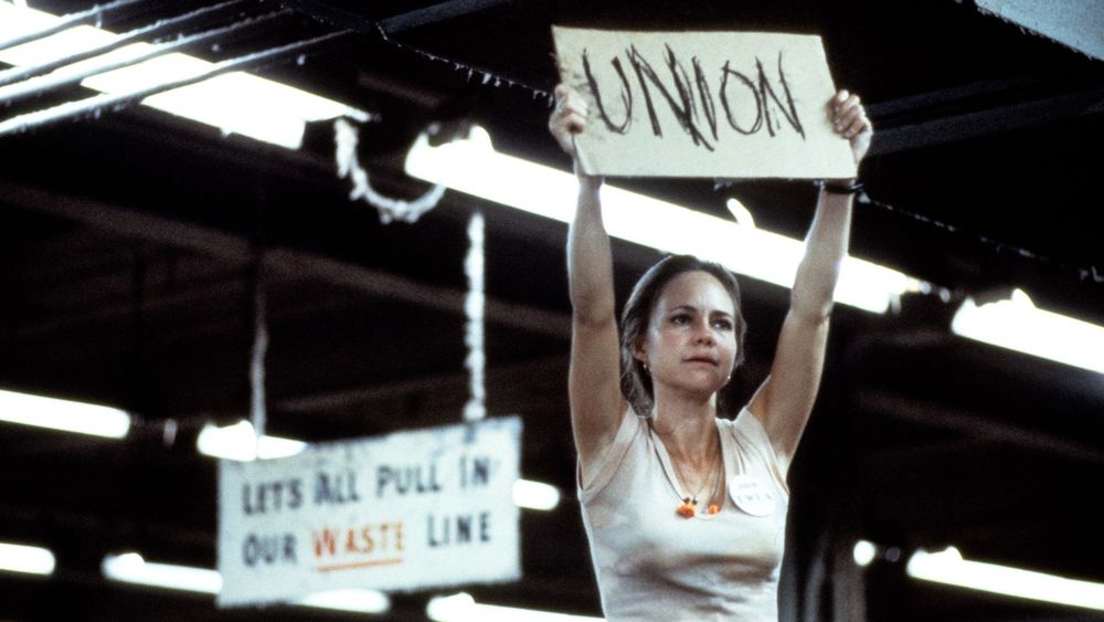 Sally Field standing on a table holding a ‘Union’ sign in Norma Rae