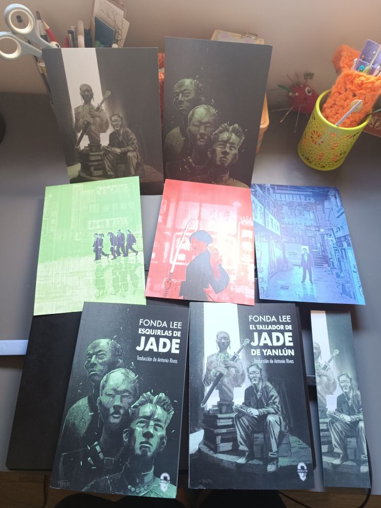 Postales de las portadas de la saga de los huesos verdes, marcapáginas y los libros Esquirlas de Jade y El tallador de Jade