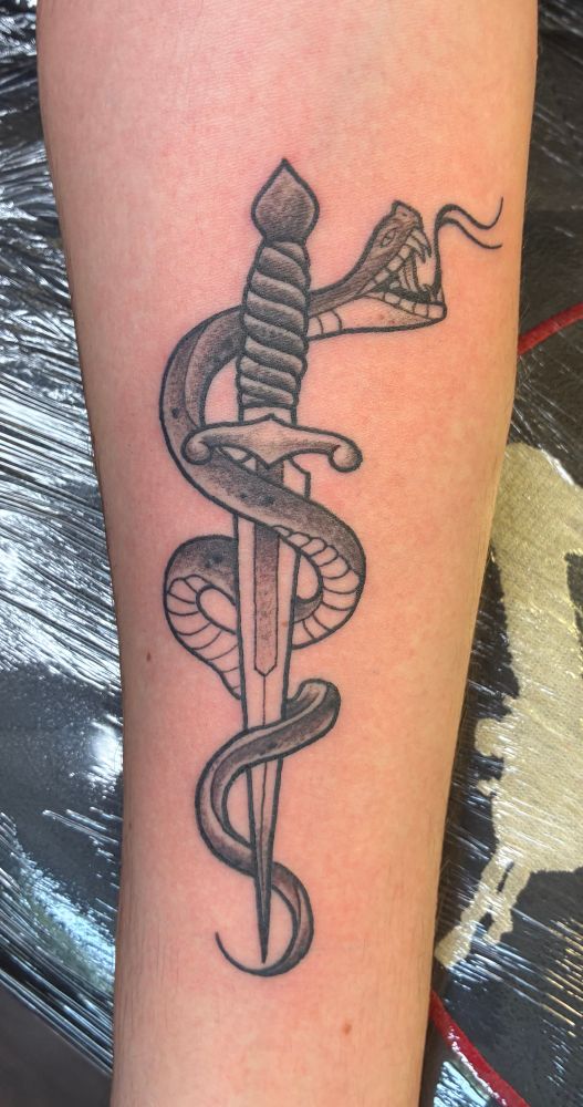 Forearm tattoo of a snake coiled around a dagger
