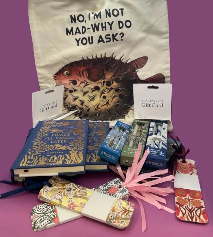 Selection of prizes for a prize draw, including a tote bag with a puffer fish that says "No, I'm not mad - why do you ask?", some planners with "Things I'll cancel later" on the front cover, a selection of pens and bookmarks, and gift cards