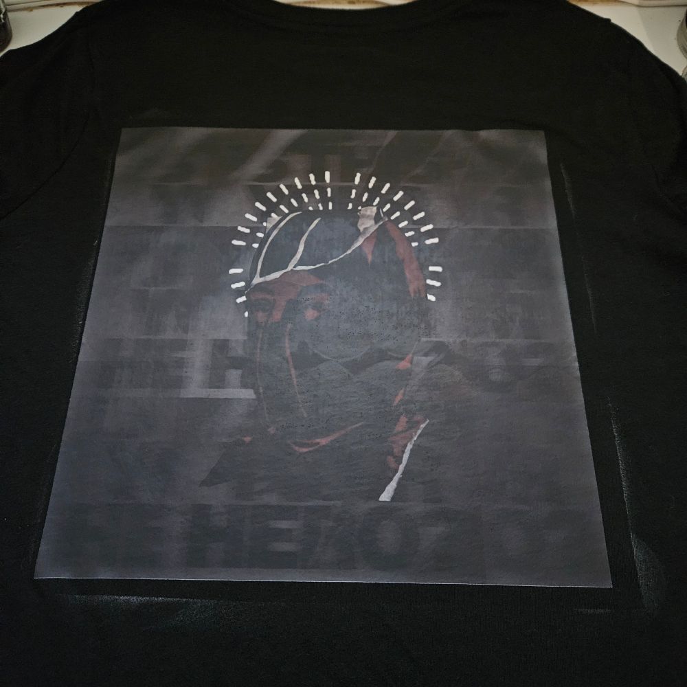 Black shirt with edited graphic of Clancy with IS HE YOUR HERO on the back.