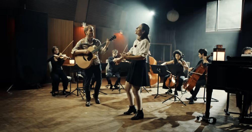 Lorien Testard with an orchestra and choir performing "Lumiere" in the official music video