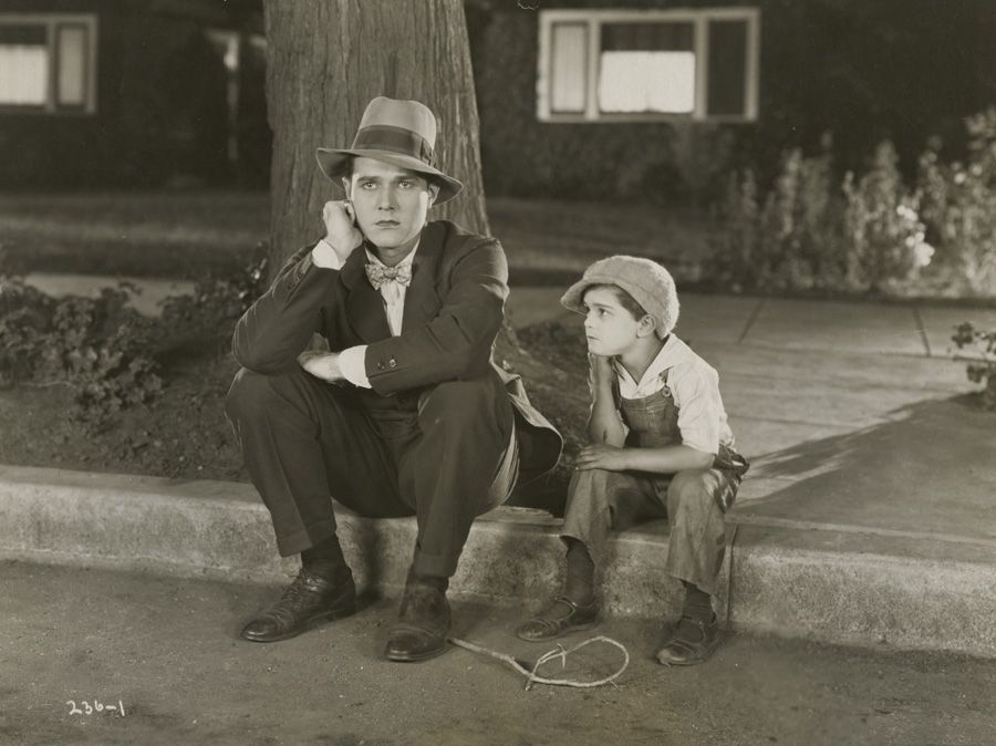 William "Billy" Haines (left) and Frankie Darro share a thoughtful moment on a curb in MEMORY LANE.