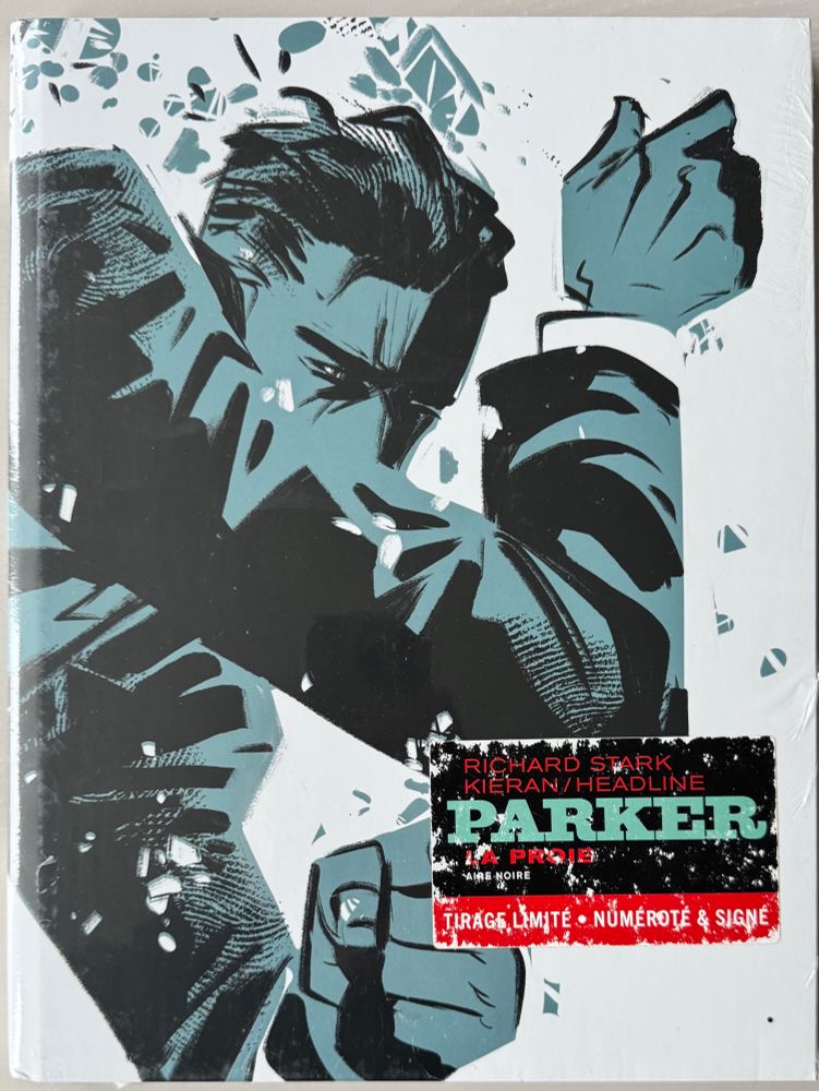 C’est une édition limitée et signée de Parker: La Proie, une adaptation du roman de Richard Stark (Donald Westlake) illustrée par Darwyn Cooke.

La couverture est percutante, dans un style graphique très marqué : un dessin en noir et bleu-vert représentant Parker en plein mouvement, poings levés, comme en train de frapper ou d’éviter un coup. Le design brut et expressif rappelle l’esthétique des polars noirs des années 60. L’étiquette indique clairement qu’il s’agit d’un tirage limité, numéroté et signé.

Une BD qui transpire l’ambiance dure et implacable du personnage de Parker !