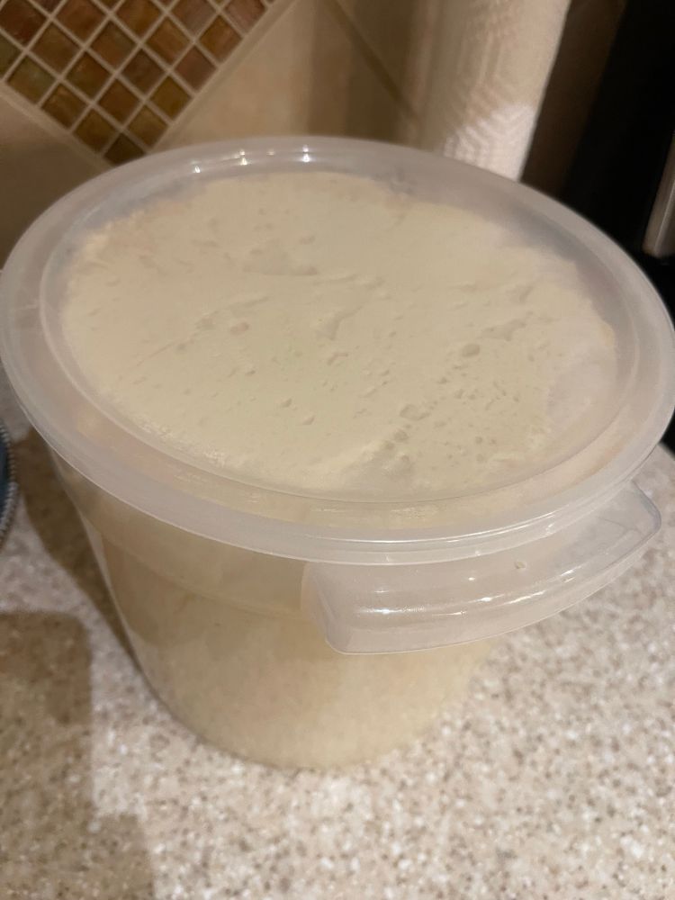 Dough bucket filled to the top with dough. 