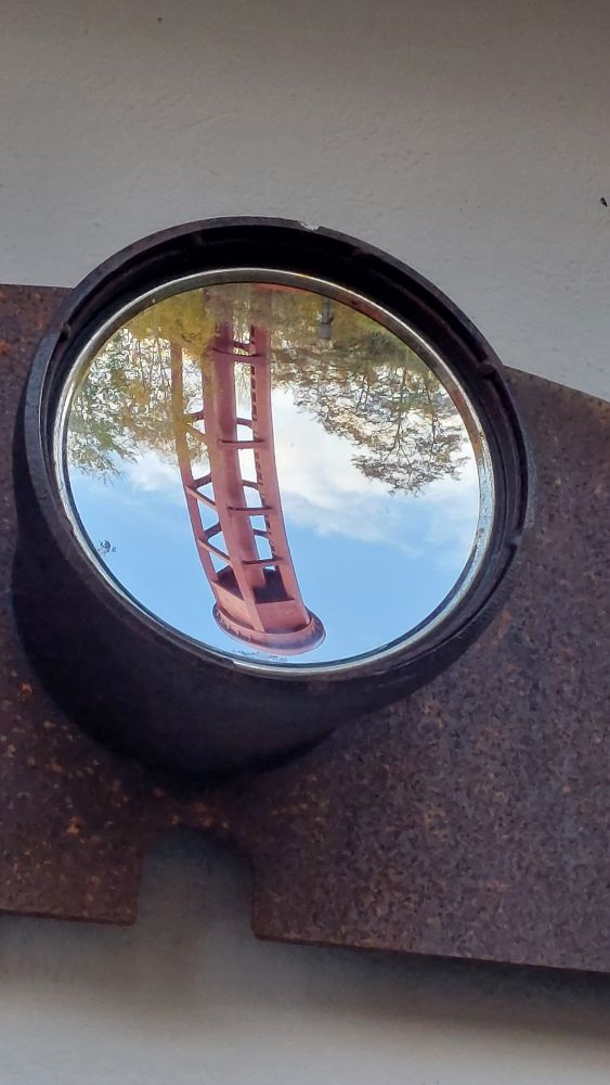 In einer Kunstinstallation (Spiegel) erscheint der alte rote Wasserturm auf den Kopf gestellt. 