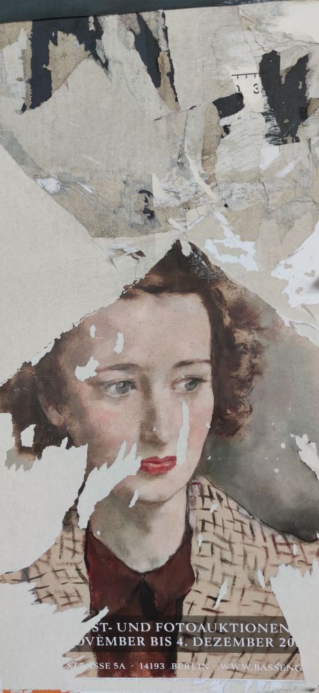 Plakat in der Berliner U-Bahn. Halb abgerissen, dadurch erregte es aber meine Aufmerksamkeit. Den abgebildeten Frauenkopf kann man noch gut erkennen.