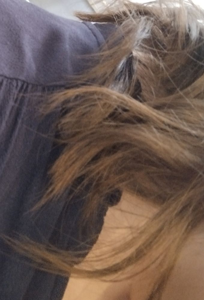 Wavy brown hair and a snippet of white skin and a dark blue dress 