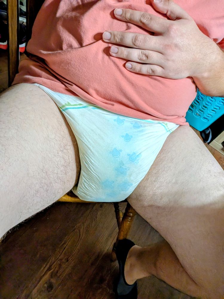 Sitting on a chair showing my wet diaper.