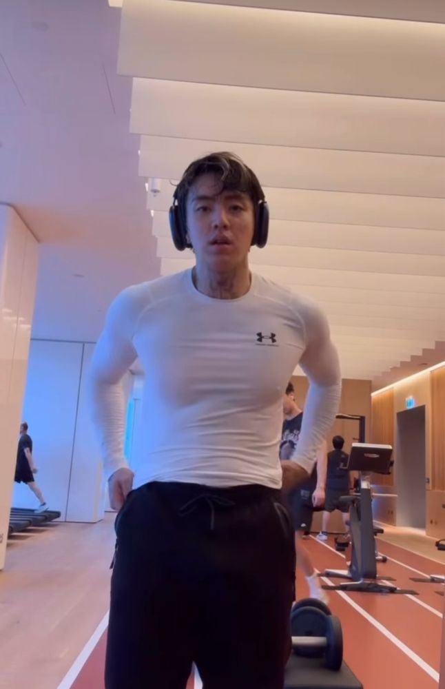 screenshots of dpr ian at the gym. wearing white compression shirt and airpod maxes