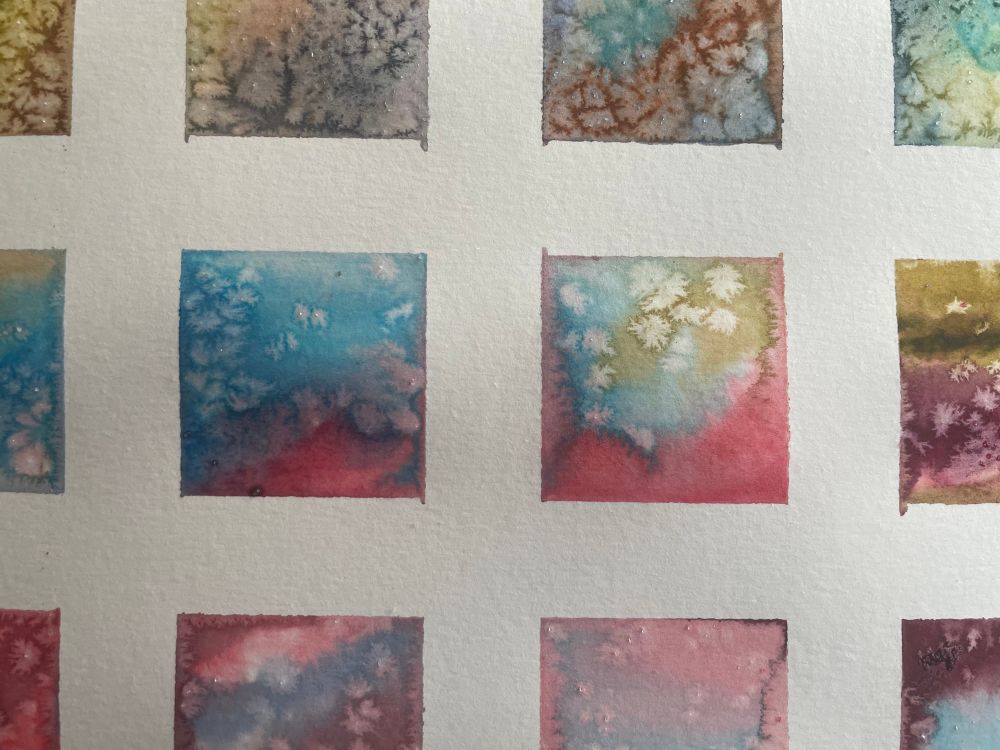 Square shaped small watercolor paintings with varying colors and splotchy shapes