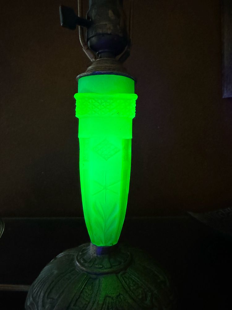 A uranium glass lamp glowing under a UV light.