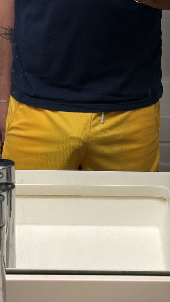 Man in yellow shorts taking a mirror picture