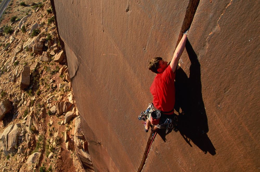 A clean hand crack is a thing of beauty.  A man climbs a splitter crack up a wall, jamming his hands and feet into the crack to step up the wall.
