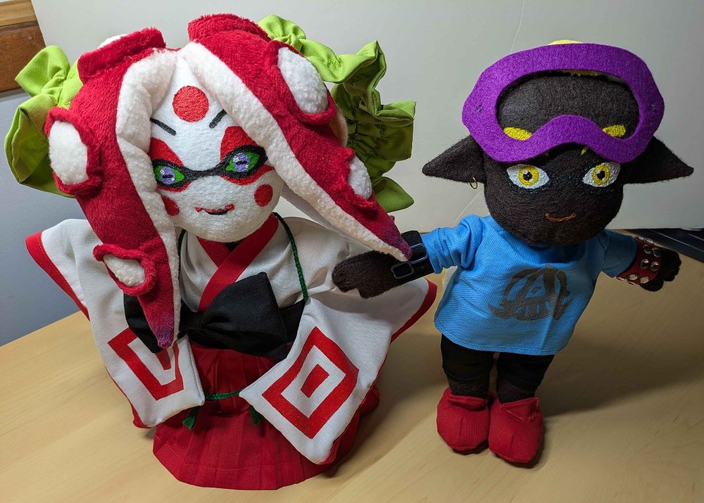 Two Splatoon ocs; one a male Inkling and the other a female Octoling in Kabuki inspired attire stand side my side. They are both handmade plush and have been made with a lot of love and care.