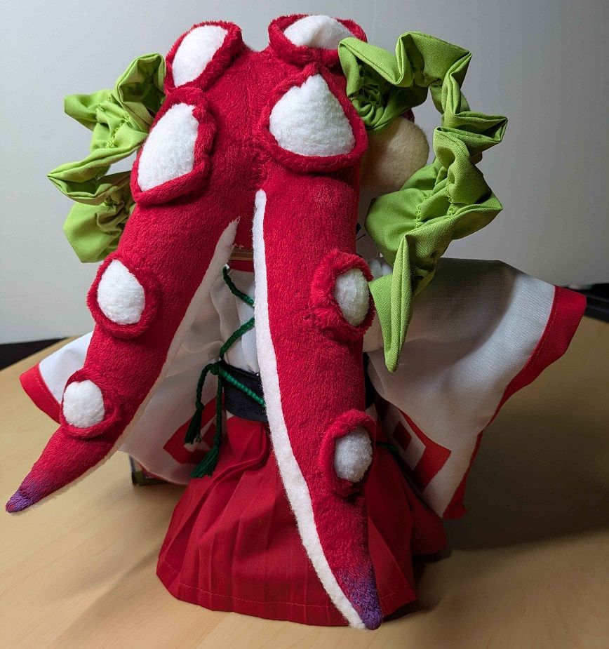 Full body picture of a handmade plushie of a Splatoon oc who happens to be a female Octoling dressed in kabuki inspired attire. The image shows what the plush looks like from the back. She has been made with a lot of love and care.