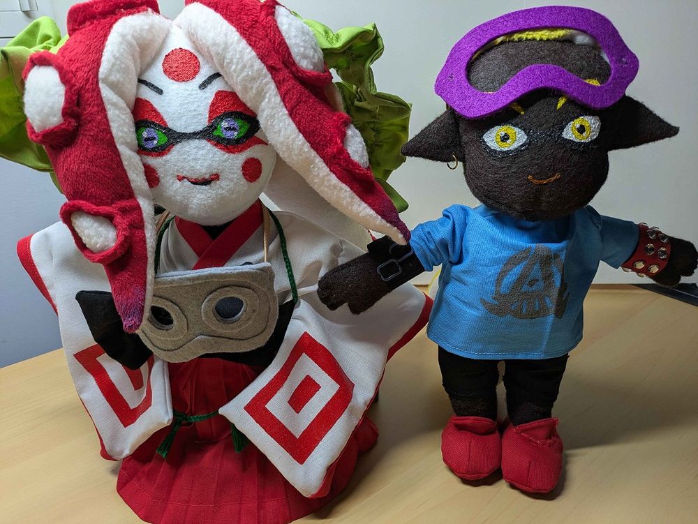 Two Splatoon ocs; one a male Inkling and the other a female Octoling in Kabuki inspired attire stand side my side. Avia is wearing her Octoleet goggles around her neck in this image. They are both handmade plush and have been made with a lot of love and care.