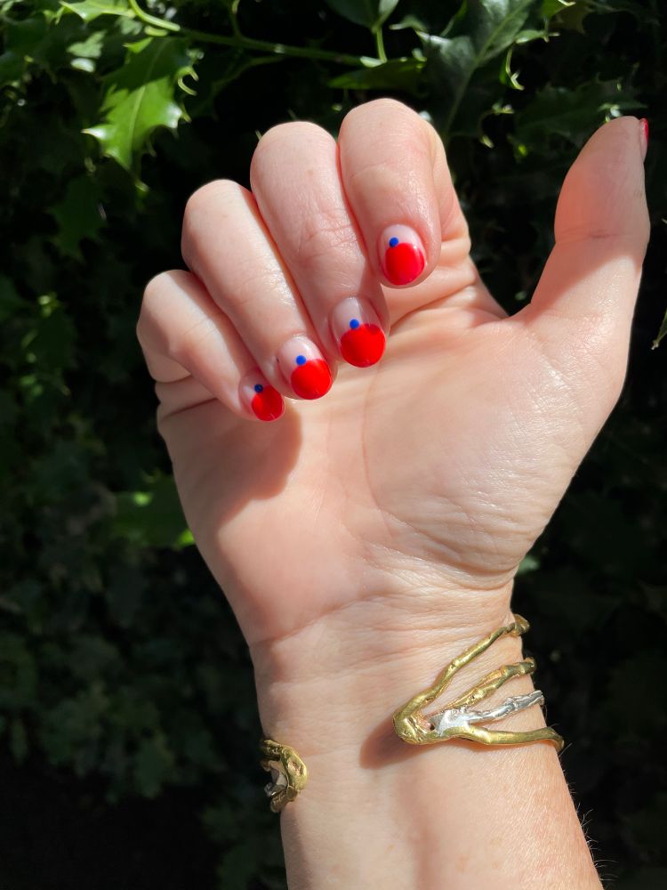 New manicure. Short nails, half red with a blue dot