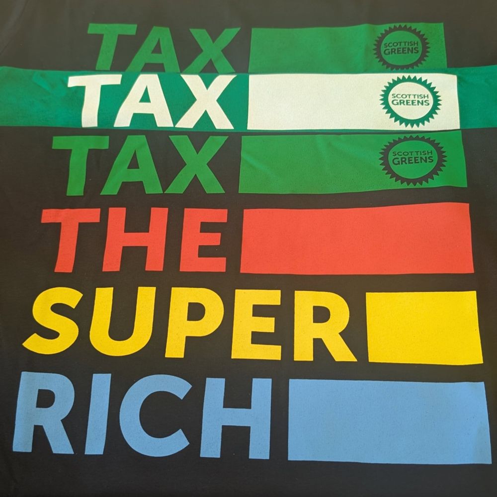 Stack of Scottish Green party t-shirts reading 'tax the super rich'