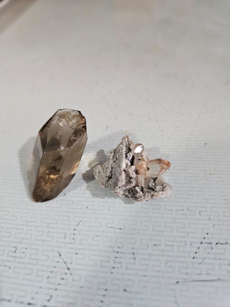 2 topaz minerals from Utah. The one on the left is about an inch tall. The one on the right is some tiny pink topaz crystals on a matrix. 