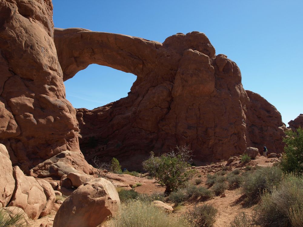 Rötlich braune Felsenlandschaft, ein großer steinerner Bogen