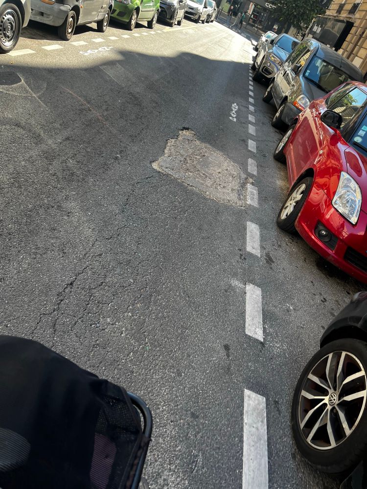 Chaussée rebouchee grossièrement par du ciment après des travaux. 