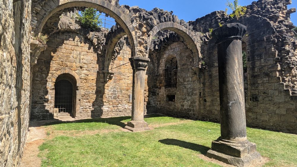 Some ruined rooms, with arches and pillars still standing but the roof missing.
