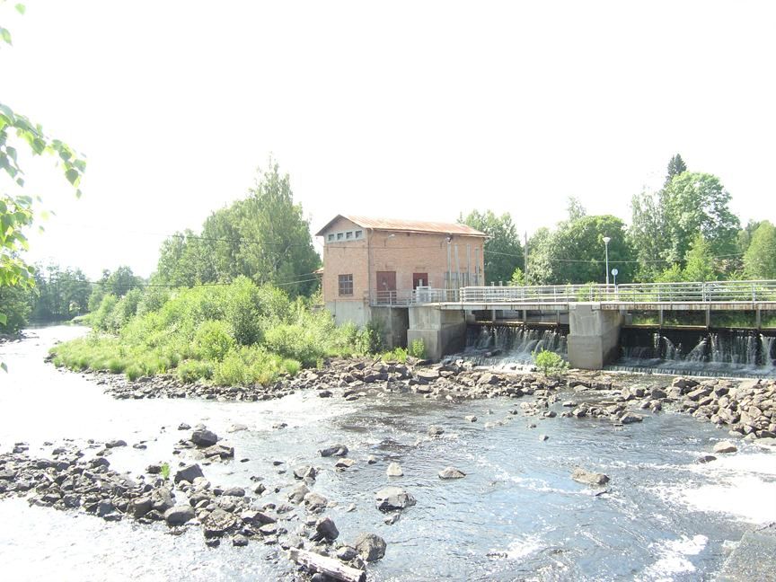 A small hydroelectric power station with a dam and a red-brick building. 