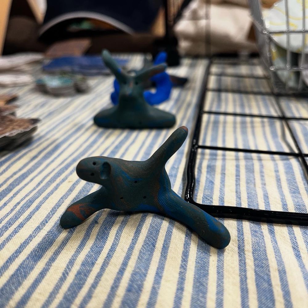 A sculpture of an excited creature doing the splits
