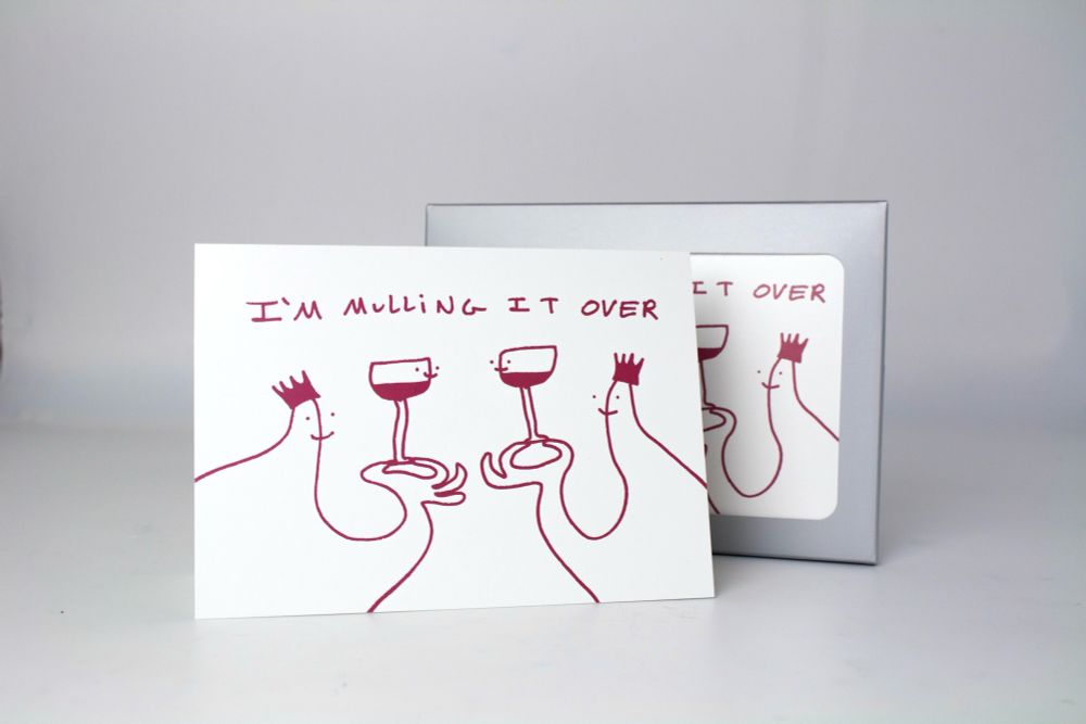 Card featuring two cartoon characters sharing glasses of mulled wine. The text reads “I’m Mulling it over”