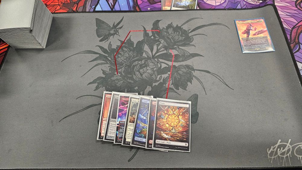 A playmat with Magic the Gathering cards on top. 