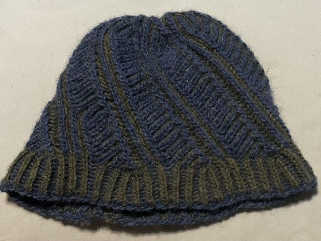 Hat knit in brioche Looks ribbed but about 3x as complicated Two colors are navy blue and forest green On this side the green is dominant at the brim and blue is dominant for the body