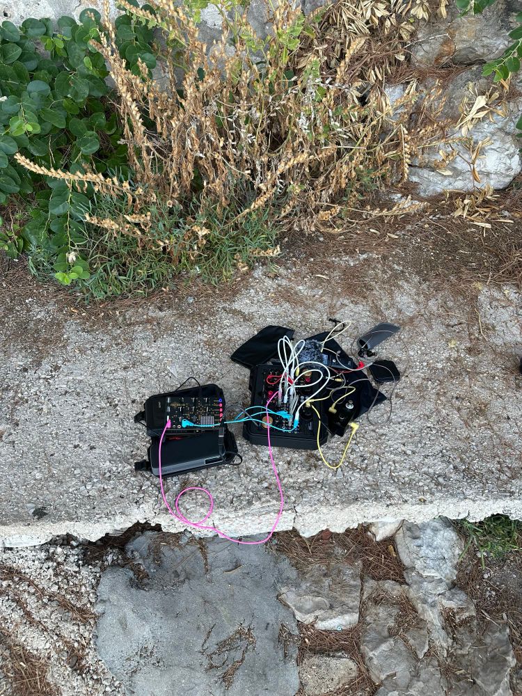 Portable modular synth set up on a rocky background 