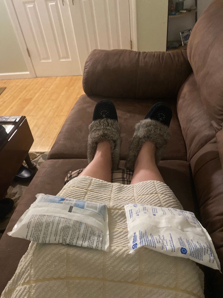 I am on the couch, you can see my feet stretched out with my fuzzy slippers and a dish towel over my knees and an ice pack precariously balanced on each knee