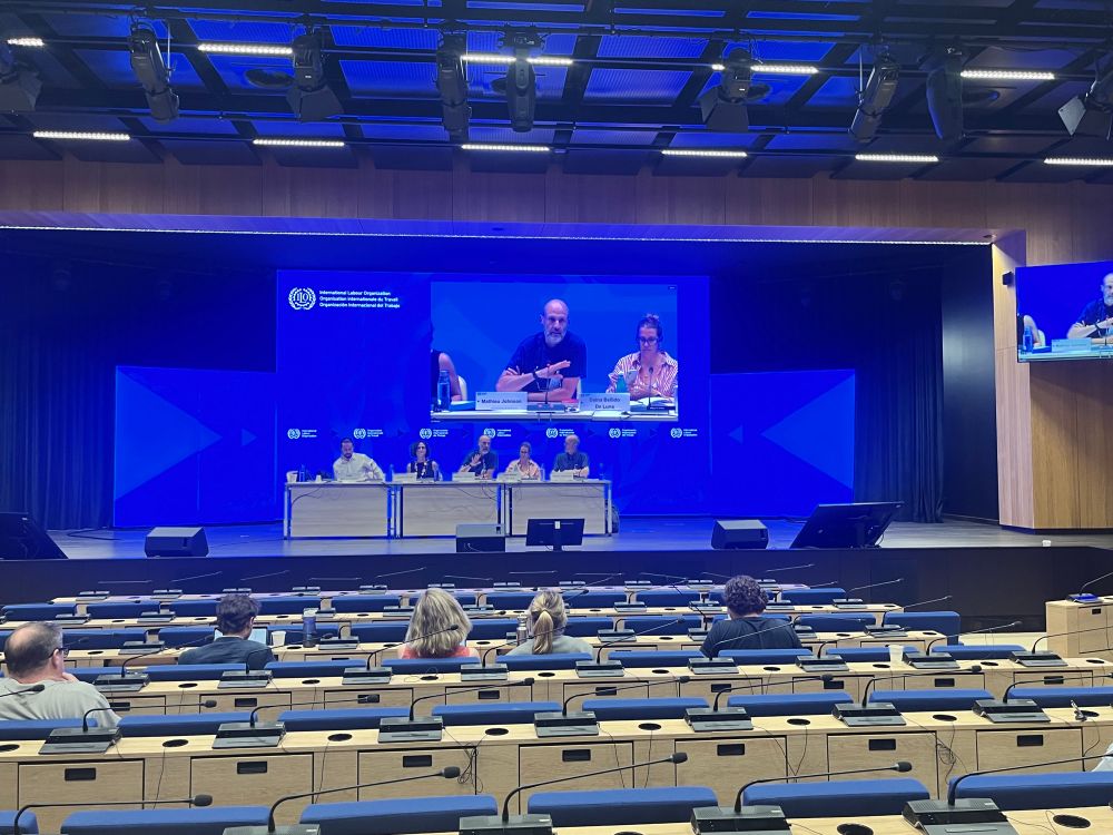 A panel of 5 people presenting at a conference