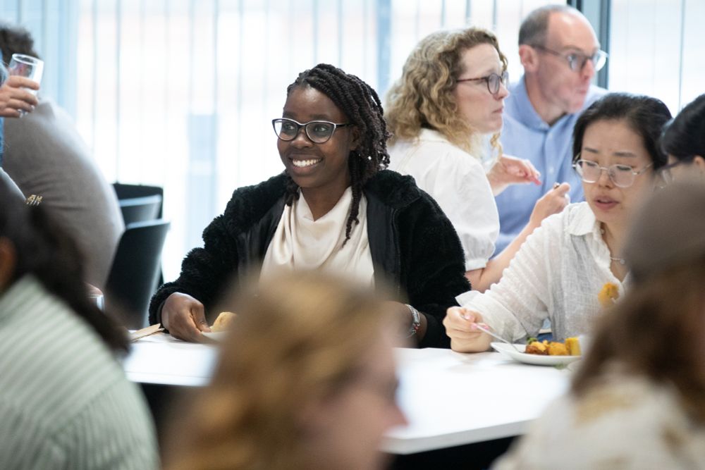 Two Grantham Scholars sitting at a table enjoying food at the summer social event.