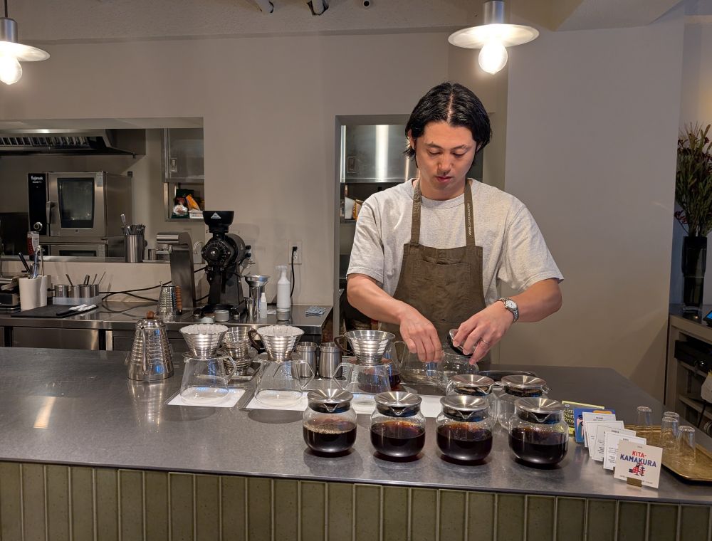 A barista in a Tokyo Verve coffee shop prepares multiple drip brewed coffees on the counter.