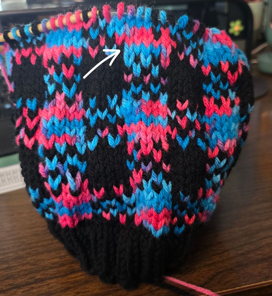 A fucked up section of a plaid pattern on a knit hat. 
