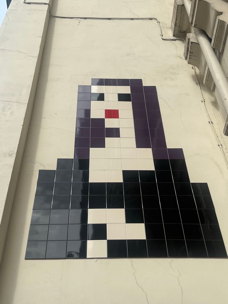 A piece of mosaic tile street art from Space Invader. It is of the Mona Lisa. 